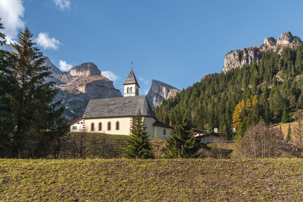 Vista della chiesetta di mazzin con le dolomiti sullo sfondo | © Archivio Immagini ApT Val di Fassa - Patricia Ramirez
